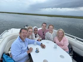 A cheerful group of friends enjoys a relaxing moment on a boat, perfect for gatherings and celebrations on the water.