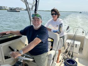 A joyful moment on the water as a man and a young boy enjoy a fishing trip together, showcasing the fun of family boating adventures.