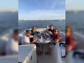 A cheerful group enjoys a meal on a boat, capturing the essence of fun and relaxation on the water — perfect for family outings or friendly gatherings.