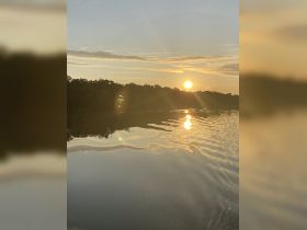 A serene sunset over calm waters, reflecting the vibrant colors of the sky — a perfect backdrop for peaceful boating experiences.