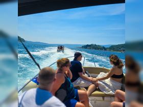 A lively group enjoys a day on the water, with a couple sharing a moment while cruising on a boat — perfect for summer adventures and creating lasting memories.