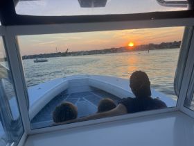 A family enjoys a picturesque sunset view from their boat, creating a memorable experience on the water.