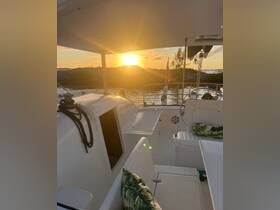 A cozy interior view of a boat with comfortable seating and a stunning sunset visible through the window, perfect for relaxing moments on the water.