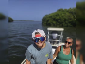 A joyful moment captured on a boat with a smiling child and adult, showcasing the fun of family outings on the water.