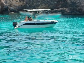A couple enjoys a sunny day on a boat in stunning turquoise waters, perfect for a romantic getaway or adventure on the sea.