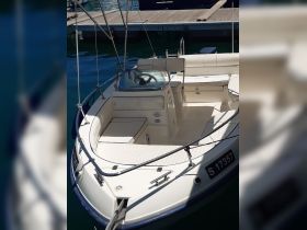 Interior view of a well-equipped boat helm and seating area, showcasing the comfortable layout ideal for day trips on the water.