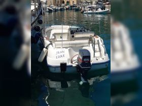 A well-maintained boat named 'JEAN LUKE' docked in a serene harbor, showcasing its sleek design and inviting atmosphere for a day on the water.