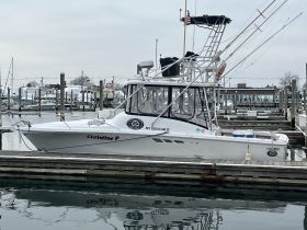 A side view of the fishing boat 'Christine P' docked at the marina, showcasing its sleek design and fishing equipment.
