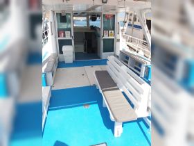 Interior view of a boat cabin featuring comfortable seating and a clean, organized layout, ideal for relaxing during a day on the water.