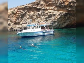 Two snorkelers enjoy the vibrant turquoise waters near a boat, showcasing a perfect day of aquatic adventure and exploration.
