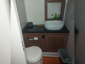 A clean and modern boat bathroom featuring a stylish sink and toilet, perfect for onboard comfort and convenience.