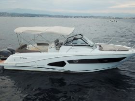 A sleek speedboat captured from the side, showcasing its elegant design as it glides through calm waters — perfect for a day of adventure on the sea.