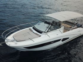 A stunning aerial view of a sleek yacht cruising through deep blue waters, showcasing its elegant design and spacious deck.