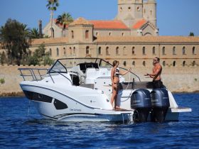 A couple enjoys a sunny day on a boat, engaging in playful interaction against a picturesque backdrop — perfect for summer adventures on the water.