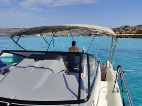 A scenic view from the helm of a boat, showcasing turquoise waters and guests enjoying the beautiful surroundings — perfect for a day of adventure on the water.