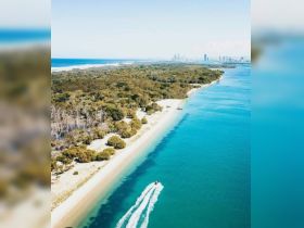 A stunning aerial view of a pristine coastline with turquoise waters and lush greenery, showcasing the beauty of nature and ideal for exploring by boat.