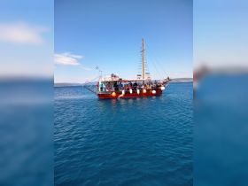 A vibrant boat filled with guests enjoys a day on the water, showcasing the perfect setting for group adventures and sightseeing.