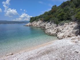 A stunning view of a serene coastline with clear turquoise waters and rocky shores, perfect for a relaxing beach day or exploring nature.
