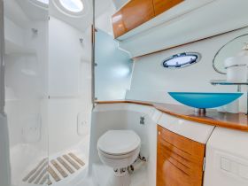 A clean and modern boat bathroom featuring a stylish sink and shower area, perfect for onboard comfort and convenience.