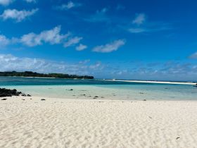 A stunning view of a serene beach with turquoise waters and a clear blue sky, perfect for relaxing and enjoying nature's beauty.