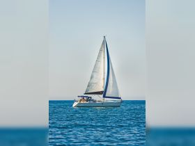 A beautiful sailboat glides through calm waters, showcasing its elegant sails and inviting atmosphere for a perfect day on the sea.