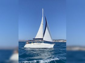 A beautiful sailboat glides through the sparkling waters, showcasing a perfect day for sailing adventures. Ideal for exploring coastal destinations.