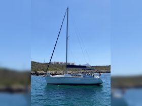 A beautiful sailboat anchored in clear waters, showcasing its sleek design against a sunny backdrop — perfect for sailing adventures.