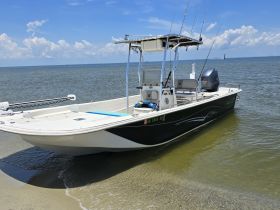 A sleek speedboat docked in shallow waters, showcasing its design and fishing gear, perfect for a day on the water.