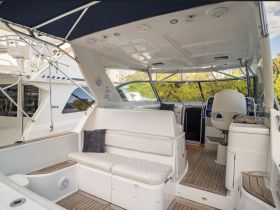 The interior of a well-appointed boat featuring comfortable seating and a helm area, perfect for relaxing or navigating on the water.