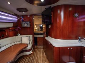 A cozy interior view of a boat's cabin featuring elegant wood finishes and comfortable seating — perfect for relaxing during a voyage.
