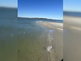 A scenic view of a sandy shoreline meeting the water, showcasing the natural beauty of the landscape.