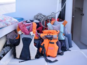 A collection of colorful life jackets neatly arranged inside a boat, ensuring safety for all passengers during water activities.