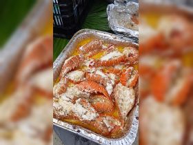 Deliciously prepared lobster tails served in a tray, perfect for onboard catering during a luxurious boating experience.