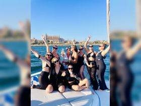 A lively group of friends celebrates aboard a yacht, enjoying drinks and the stunning backdrop of the city — perfect for unforgettable party experiences on the water.