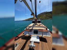 A stunning view of a sailboat's deck, showcasing its elegant wooden finish and serene surroundings, perfect for a day on the water.