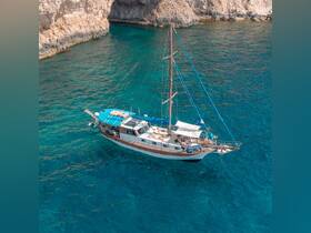 A beautiful sailing boat navigates through crystal-clear waters, with guests enjoying the sun and scenery — perfect for a memorable day on the water.