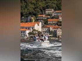 A lively group celebrates aboard a boat, enjoying the beautiful coastline and creating unforgettable memories on the water.