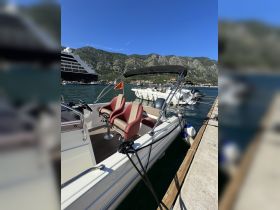 A sleek speedboat docked at the marina, showcasing its stylish design and comfortable seating, set against a stunning mountainous backdrop.