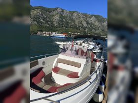 Interior view of a stylish boat featuring comfortable seating and a helm, perfect for enjoying a day on the water.