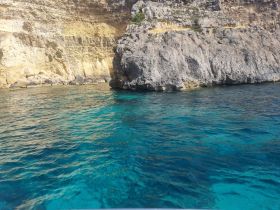 A stunning view of a rocky coastline with crystal-clear waters, perfect for exploring the natural beauty of the area.