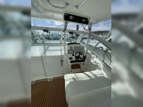 A well-appointed helm area inside a boat, featuring a sleek console and comfortable seating, perfect for navigating the waters in style.