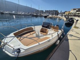 A sleek speedboat docked at a marina, showcasing its spacious seating and modern design — perfect for day trips on the water.