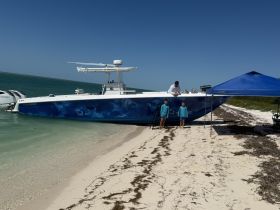 A family enjoys a day at the beach with a boat parked nearby, creating a perfect setting for fun and adventure on the water.