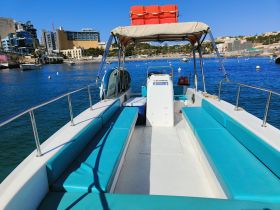 A bright and spacious interior view of a boat featuring comfortable seating, perfect for enjoying a day on the water.