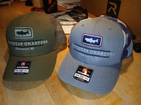 A pair of stylish caps from Whitecap Charters in Charlevoix, MI, perfect for fishing enthusiasts and charter boat adventures.