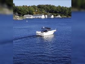 A sleek speedboat named 'Double Trouble' glides through calm waters, showcasing the beauty of a serene boating day.
