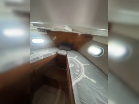 Cozy interior cabin of a boat featuring twin beds and wooden furnishings, perfect for comfortable overnight stays while cruising.