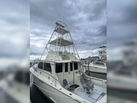 A detailed view of a fishing boat docked at the marina, showcasing its structure and design under a cloudy sky.