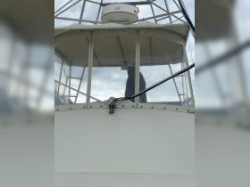 A view of the helm area inside a boat, showcasing the console and a person at the controls, perfect for navigating the waters.