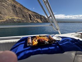 A beautifully arranged platter of fruits and snacks on a boat, perfect for enjoying while cruising along scenic coastlines.